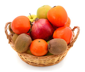 Tangerines, pomegranate and kiwi in a basket.