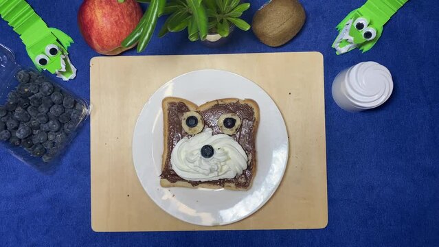 Chocolate spread on a bread decorated like a bear spinning in the plate. High quality 4k footage