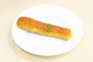 Pistachio kadayif on a plate. Turkish Dessert Kadayif with pistachio powder. Kunefe. Local name burma kadayif