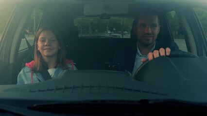 Close up of happy family going on family trip laughing in car together. Handsome young father...