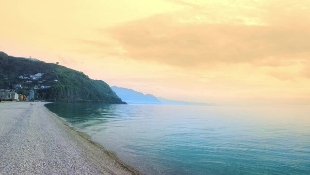 Beautiful tropical panoramic view of village in Gonio in Georgia with beach, sea. Concept of beach against backdrop of mountains at sunset.Flight of drone over pebble shore. Sea view from air,