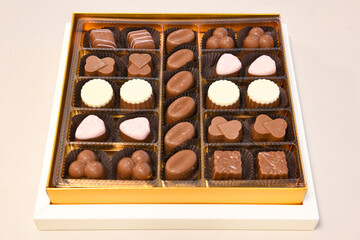 Various handmade chocolates with nuts arranged on  table with peanut butter and cinnamon sticks