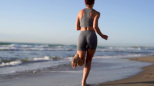 girl goes in for sports on the seashore on the sand does exercises