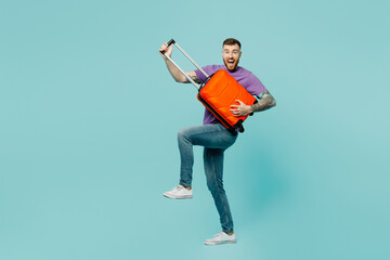 Young traveler man wear casual clothes hold suitcase pov guitar isolated on plain pastel green...