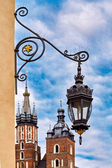 Fototapeta na wymiar vintage retro lantern and beautiful medieval towers of St Mary's Basilica in day light, Krakow, Poland