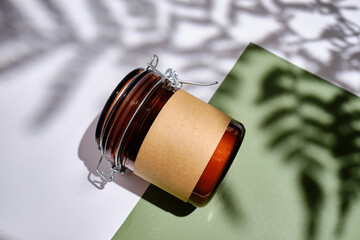 Brown glass jar and a label on a light background. Beauty blog, salon therapy, product packaging,...