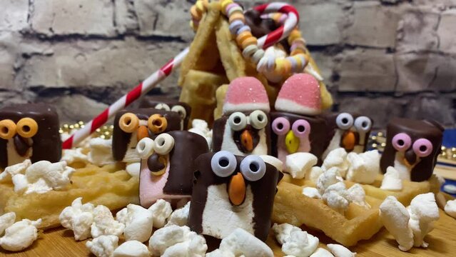 Creative food decoration. Sweet marshmallow penguins and the waffle house. Desserts and sweets. High quality 4k footage