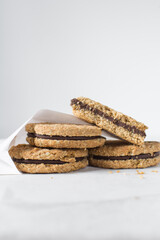 oat cookies with chocolate filling, homemade oatmeal cookies filled with chocolate ganache, thin oat biscuits with chocolate ganache	