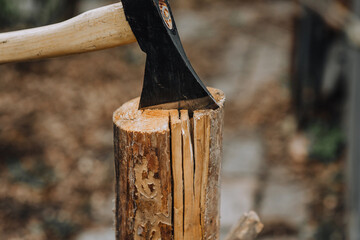 Chopping a log, tree with an ax outdoors, nature, in the forest close-up. Photography, work concept.