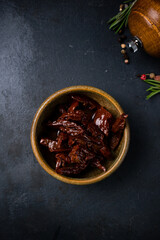 Dried tomatoes in oil in a ceramic bowl.