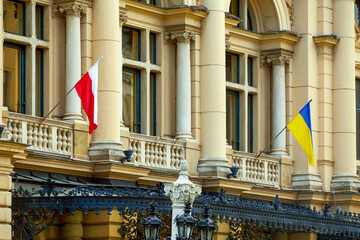 Fototapeta Ukrainian and Polish flags on the facade of the Juliusz Slowacki Theatre. is a 19th-century Eclectic theater-opera house in the heart of Krak w, Poland, and a UNESCO World Heritage Site. obraz