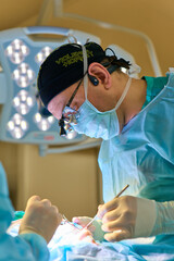 plastic surgeon operates on a patient in the operating room
