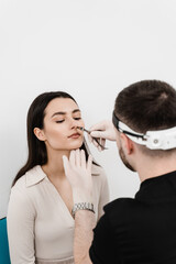 Otolaryngologist examines girl nose before procedure of endoscopy of nose. Consultation with ENT...
