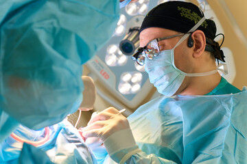 plastic surgeon operates on a patient in the operating room