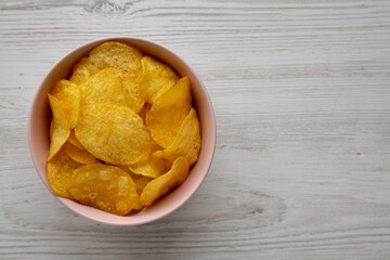 Crunch Green Onion Potato Chips in a Pink Bowl, top view. Flat lay, overhead, from above. Copy space.