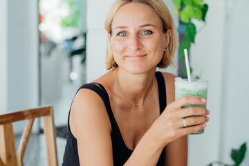 Portrait beautiful blonde woman drinking cold iced coffee beverage and enjoying summer vacation 