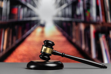 Focus wooden gavel hammer on blurred background of lawyer working or studying at library. Lawful...
