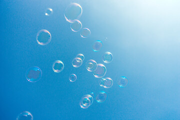 Soap bubbles flying in the clear sky.