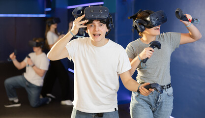guy takes break while VR play with girl.excited guy took off his virtual reality helmet to take little rest. Pastime for urban youth