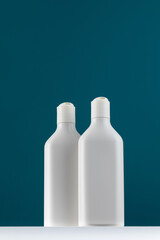 A white mock-up of a bottles with cosmetic accessories on a white shelf. Shower gel with a place for your logo.