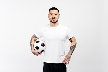 Portrait of confident successful sports man, football player holding ball looking at camera isolated on white background. Sport, competition, healthy lifestyle concept 