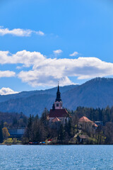 Fototapeta premium Famous alpine Bled lake (Blejsko jezero) in Slovenia, amazing autumn landscape. Scenic view of the lake, island with church, Bled castle, mountains and blue sky with clouds, outdoor travel background