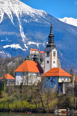 Fototapeta premium Famous alpine Bled lake (Blejsko jezero) in Slovenia, amazing autumn landscape. Scenic view of the lake, island with church, Bled castle, mountains and blue sky with clouds, outdoor travel background