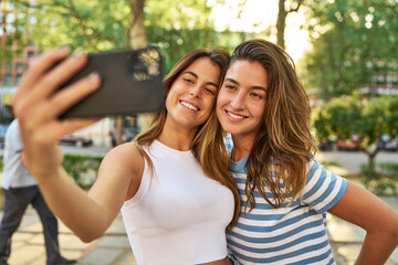 Fototapeta na wymiar Smiling friends taking a selfie in the park.