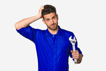 Young mechanic man holding a wrench being shocked, she has remembered important meeting.