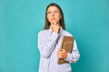 A young caucasian secretary woman isolated looking sideways with doubtful and skeptical expression.