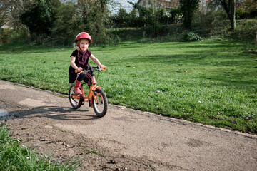 Petite fille rayonnante en vélo dans le parc