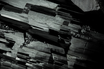 Schorl (black tourmaline) crystal structure. macro detail texture background. close-up raw rough...