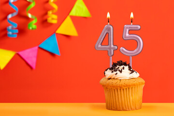 Birthday cake with number 45 candle - Sparkling orange background with bunting