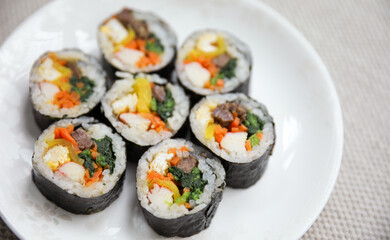 Kimbap is a traditional Korean dish made of rice, vegetables, and meat or seafood rolled in seaweed. It represents the country's rich culinary heritage and cultural diversity
