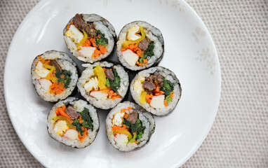 Kimbap is a traditional Korean dish made of rice, vegetables, and meat or seafood rolled in seaweed. It represents the country's rich culinary heritage and cultural diversity