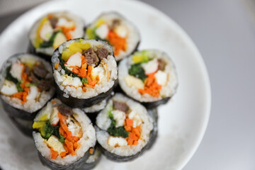 Kimbap is a traditional Korean dish made of rice, vegetables, and meat or seafood rolled in seaweed. It represents the country's rich culinary heritage and cultural diversity