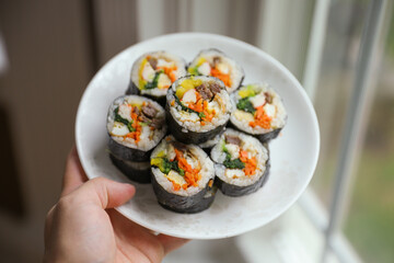 Kimbap is a traditional Korean dish made of rice, vegetables, and meat or seafood rolled in seaweed. It represents the country's rich culinary heritage and cultural diversity