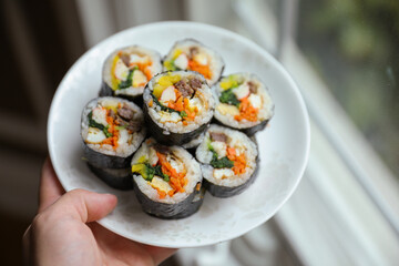 Kimbap is a traditional Korean dish made of rice, vegetables, and meat or seafood rolled in seaweed. It represents the country's rich culinary heritage and cultural diversity