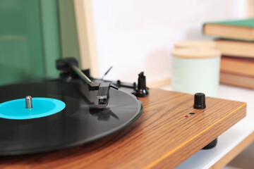 Stylish turntable with vinyl record indoors, closeup. Space for text
