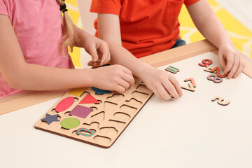 Fototapeta premium Children playing with math game kit at desk indoors, closeup. Learning mathematics with fun