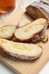 Obraz na płótnie Canvas Pieces of delicious yeast dough cake on wooden board, closeup