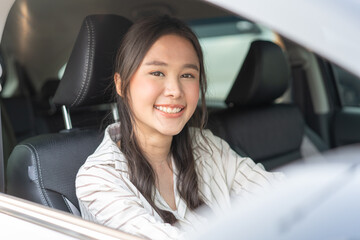 happy Asian woman driving car to journey vacation destination.