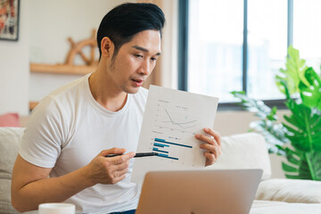 portrait of asian man sitting on sofa at home