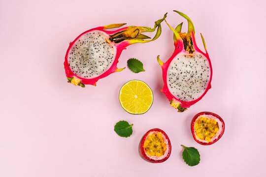 tropical fruits on a pink background. Pitahaya, dragon fruit, passion fruit, lime, mint. Fruits for a refreshing cocktail