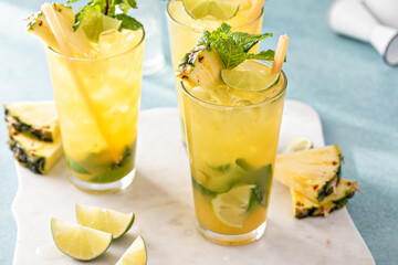 Pineapple mojito with limes and mint and a slice of pineapple