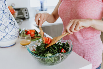 hands of Latin woman preparing salad bowl in kitchen at home in Mexico, Hispanic female healthy eating 