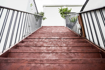 Red cement steps in the city Closeup concrete staircase with railing, old staircase detail, abstract stone staircase background.