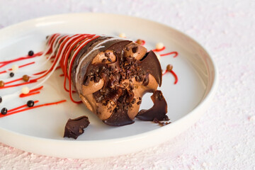 Cocoa and caramel cornet ice cream designed with decorative candy in a white plate