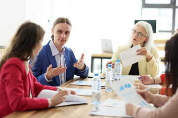 Young manager performs information to coworkers at meeting