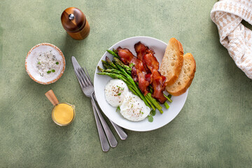 Healthy breakfast with poached eggs, bacon and asparagus